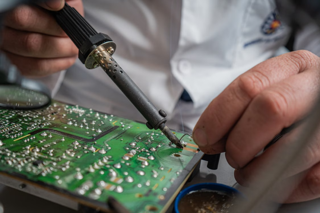 Electronics technician diagnosing a faulty device before estimating the cost and feasibility of local repair.